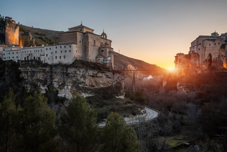 Explore ancient streets and stunning architecture in Cuenca, Spain during a picturesque sunset, cliff with castleの写真素材