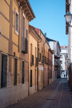 Narrow street lined with colorful buildings in a historic neighborhood on a sunny day, Alcala De Henares, Spainの写真素材