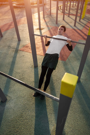young athletic man exercising at fitness calisthenics workout and do australian pull-ups or inverted...