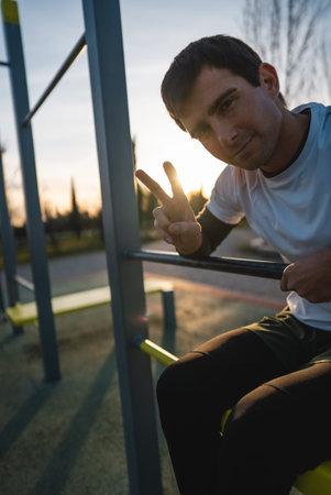 cheerful athletic man resting after exercising abs bench crunch at fitness calisthenics workout at...