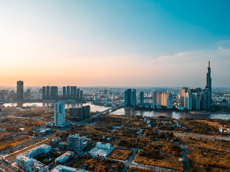 beautiful sunset over Ho Chi Minh city skyline and Saigon river, green tropical park and financial downtown district with tall skyscraper towers, Vietnam aerial drone viewの写真素材