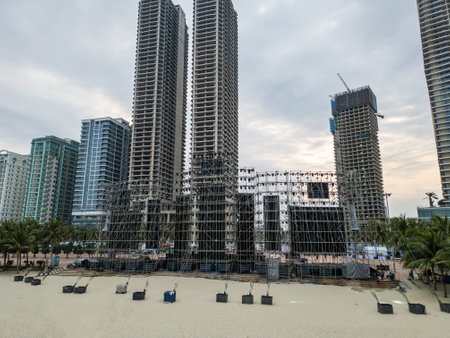 Rear View of a Beach Stage Setup Amidst Towering Skyscrapers and Construction, Backside of a Coastal Festival Preparation Surrounded by High-Rise Buildings and Developmentの写真素材