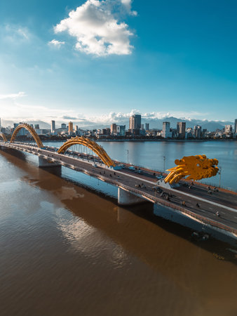 Golden Dragon Bridge over Han River in Da Nang at sunset, Iconic Vietnamese landmark spanning urban...
