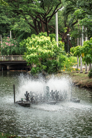 rotating water oxygen generator in park creating droplets, eco-friendly aeration device in pond producing dynamic water splashes, Lumpini park, Bangkokの写真素材