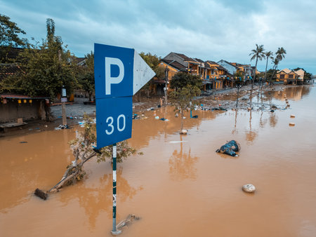 flooded city or town with buildings submerged in overflow water and mud, village underwater after heavy tropical rain and typhoon, consequences with dirt on the streetの写真素材