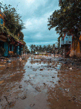 flooded city or town with buildings submerged in overflow water and mud, village underwater after heavy tropical rain and typhoon, consequences with dirt on the streetの写真素材