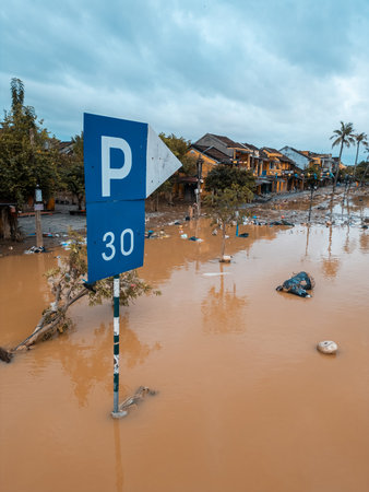 flooded city or town with buildings submerged in overflow water and mud, village underwater after heavy tropical rain and typhoon, consequences with dirt on the streetの写真素材