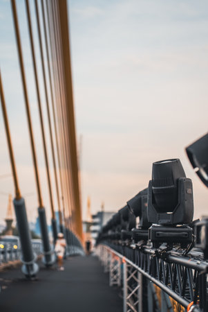 spotlights and projector lamps illuminating cable-stayed bridge at night, professional lighting equipment setup on suspension cable stayed bridge eveningの写真素材