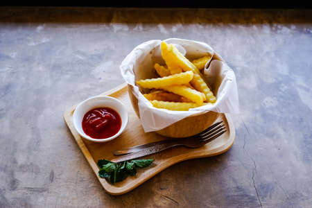 French fries with ketchup on wood trayの写真素材