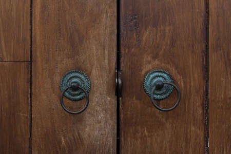 Old door handles on wooden doorの写真素材