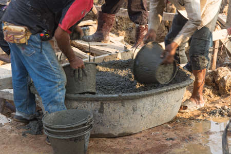Worker casting concrete at construction siteの写真素材