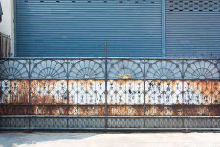 Rusty steel entrance gate closed with No entry sign ,Thai languageの写真素材