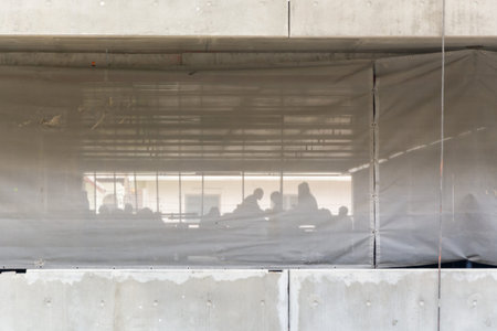 Worker in construction site with mesh sheet protection building
