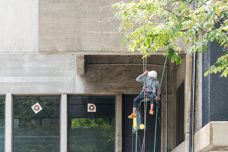 Worker cleaning old building by water jet