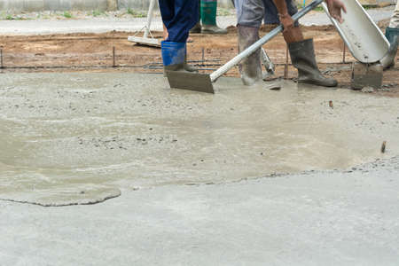 Worker casting concrete at construction siteの写真素材