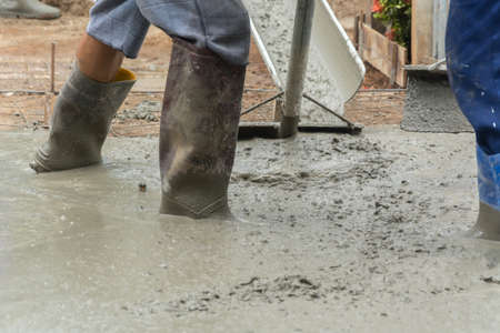 Worker casting concrete at construction siteの写真素材