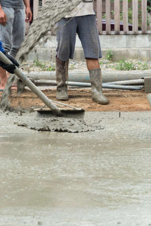 Worker casting concrete at construction siteの写真素材