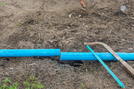Saw and pvc pipe on groundの写真素材