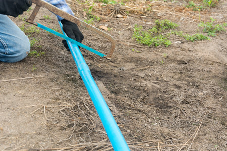 Plumber sawing a pvc pipe at field