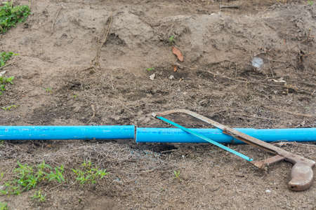 Saw and pvc pipe on groundの写真素材