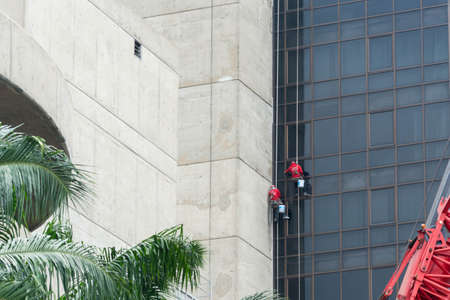 Worker cleaning the glass wall of buildingのeditorial素材