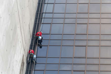 Worker cleaning the glass wall of buildingのeditorial素材