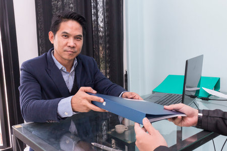 Asian businessman his colleague giving contract to read and sign,Businesspeople meeting and working...