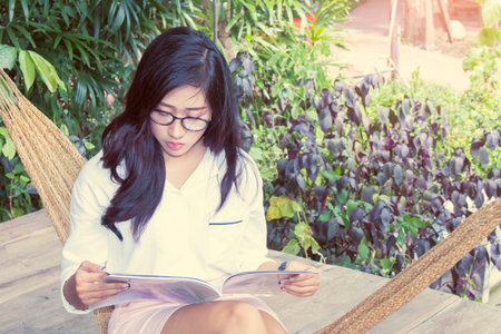 Happy woman reading a magazine in garden,Life style conceptの写真素材