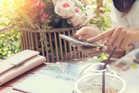 woman using smartphone in coffee shop with vintage tone.