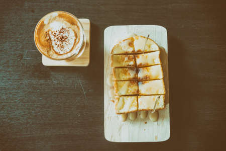 Top view of coffee with sweet toast on wooden table,vintage toneの写真素材