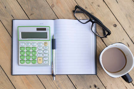 calculator,pen,notebook,spectacles,coffee cup on wooden backgroundの写真素材