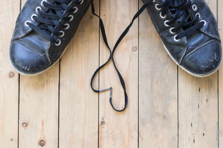 Black sneakers with heart on wooden backgroundの写真素材