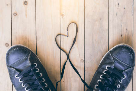 Black sneakers with heart on wooden backgroundの写真素材