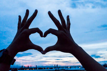 love shape hand silhouette in skyの写真素材