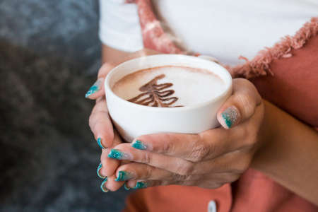 female hands holding a cup of hot coffee,food background,coffee time conceptの写真素材