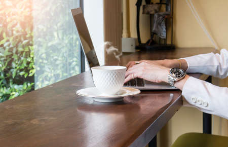 White coffee cup with business women using laptopの写真素材