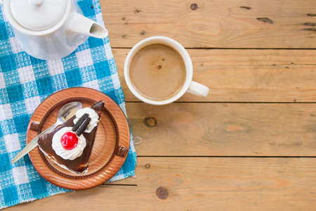 Delicious chocolate cake with hot coffee on wooden table in morning breakfast,top viewの写真素材