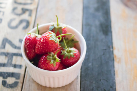 fresh strawberry in cup on wood table