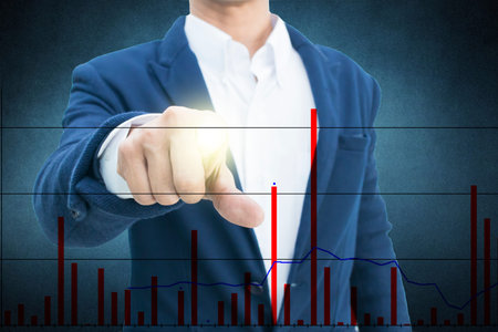 Businessman in suit points on something  on dark background