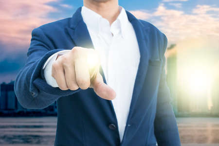 Businessman in suit points on something  on dark backgroundの写真素材