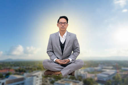 Businessman meditation on city backgroundの写真素材