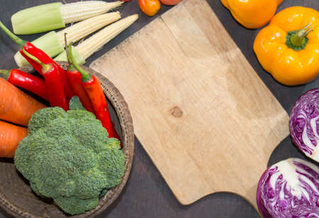 Various vegetables and spices and empty old cutting boardの写真素材