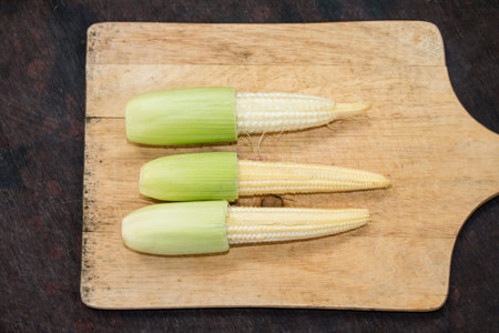 Baby corn on cutting board,young corn,food background