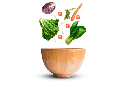 fresh vegetable falling to wooden bowlの写真素材