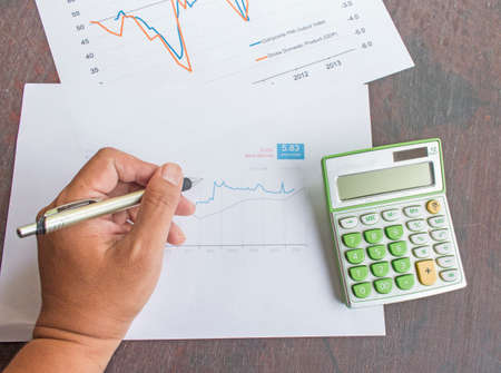 Business hand working wih the calculator and papers close upの写真素材