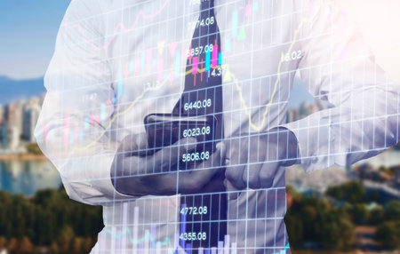 Double exposure of professional businessman use smart phone and stock chart of business financial...