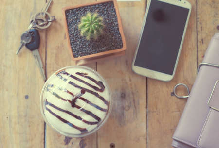 Top view coffee cup , smartphone,little cactus on wooden tableの写真素材