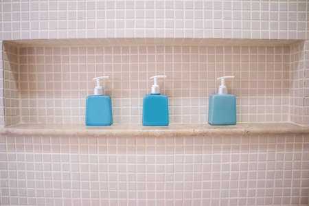liquid soap and shampoo bottle on the shelf in the bathroomの写真素材