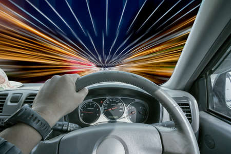 Man's hands of a driver on steering wheel  very fastの写真素材