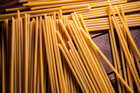 Long yellow spaghetti on wooden board,Close up